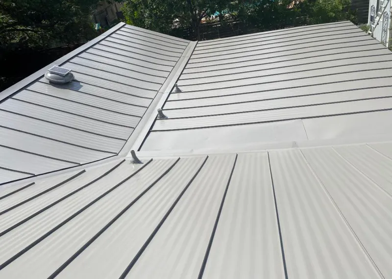 Solar attic fan installed on a metal roof for Roof Ventilation in Janesville